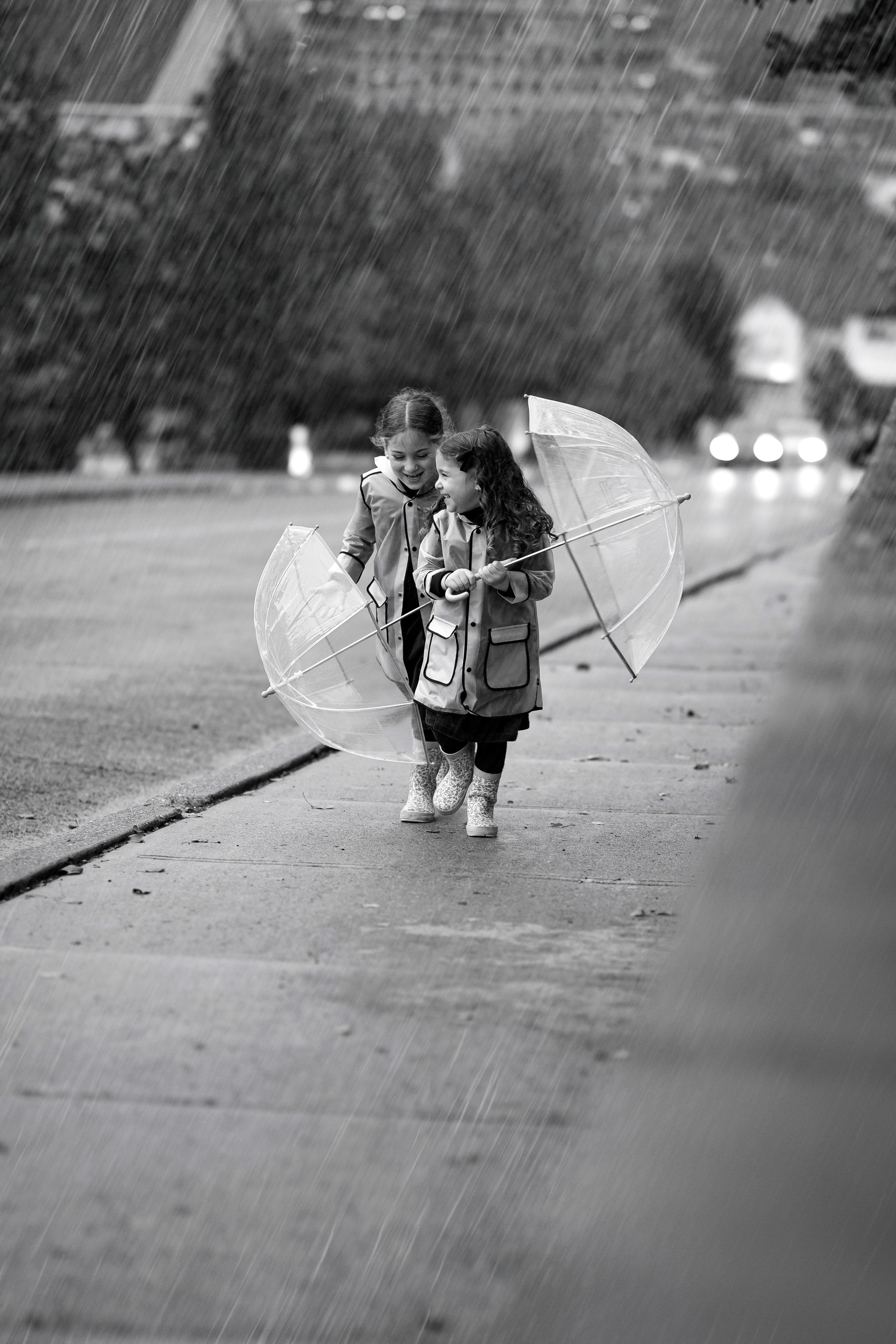 A sequence of black and white photos showing a child walking with a transparent umbrella on a rainy day.