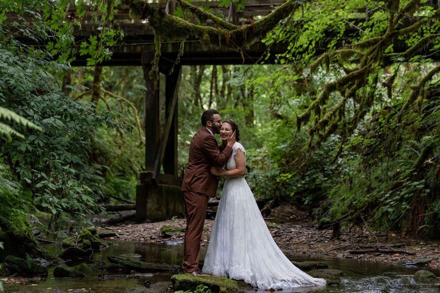 Bride and groom embracing in a creek at Camp Lane after their Ceremony.