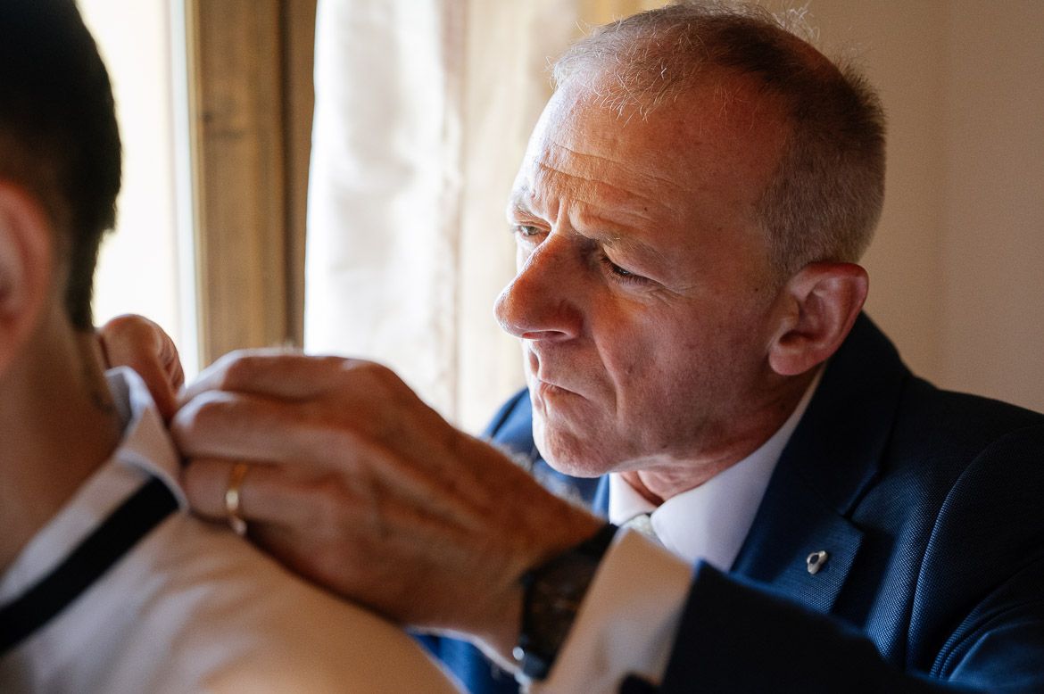 Two people in formal attire wipe their eyes with tissues during an emotional moment.
