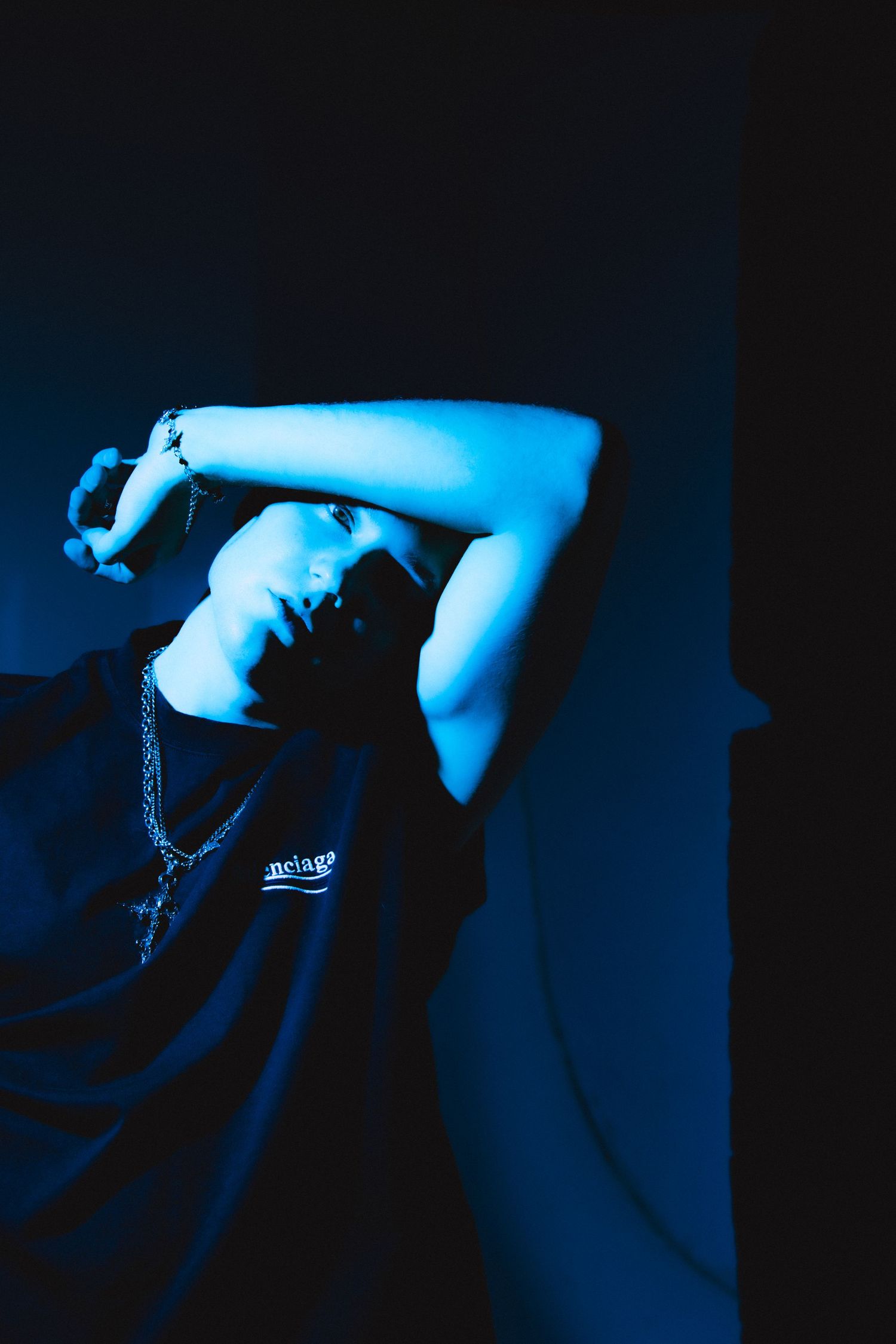 Artistic blue-toned photograph with dramatic shadows and minimal lighting.