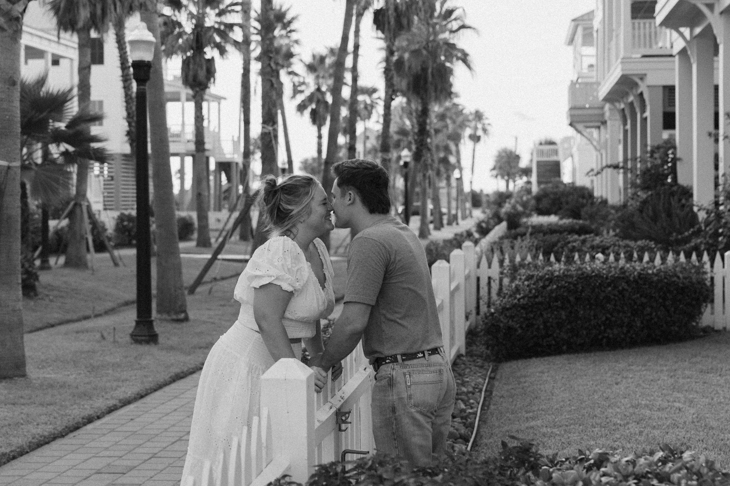 Romantic black and white wedding photos showing couples embracing on a palm tree lined path.