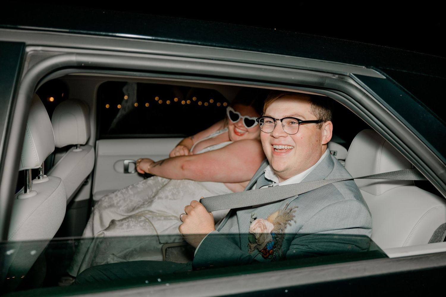 Four similar vintage-style photographs show someone in glasses sitting in the driver's seat of a car at night.