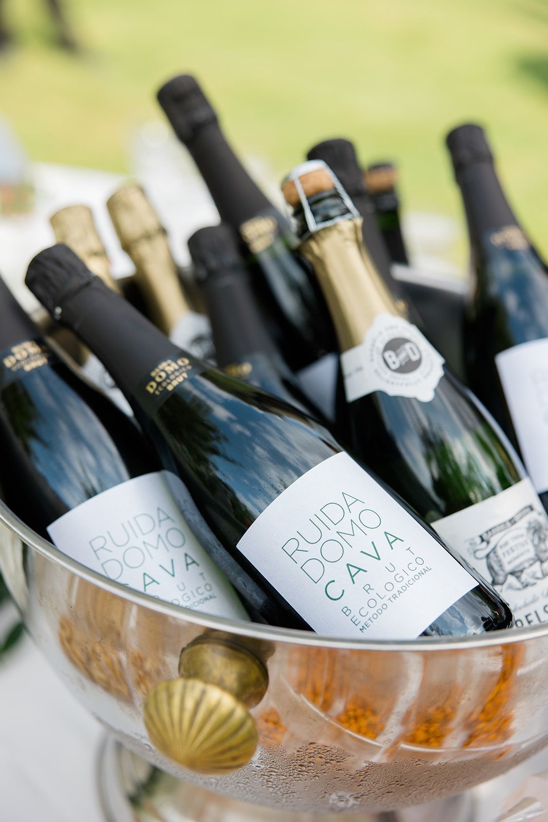 Chilled wine bottles resting in an elegant gold-rimmed champagne bowl filled with ice.