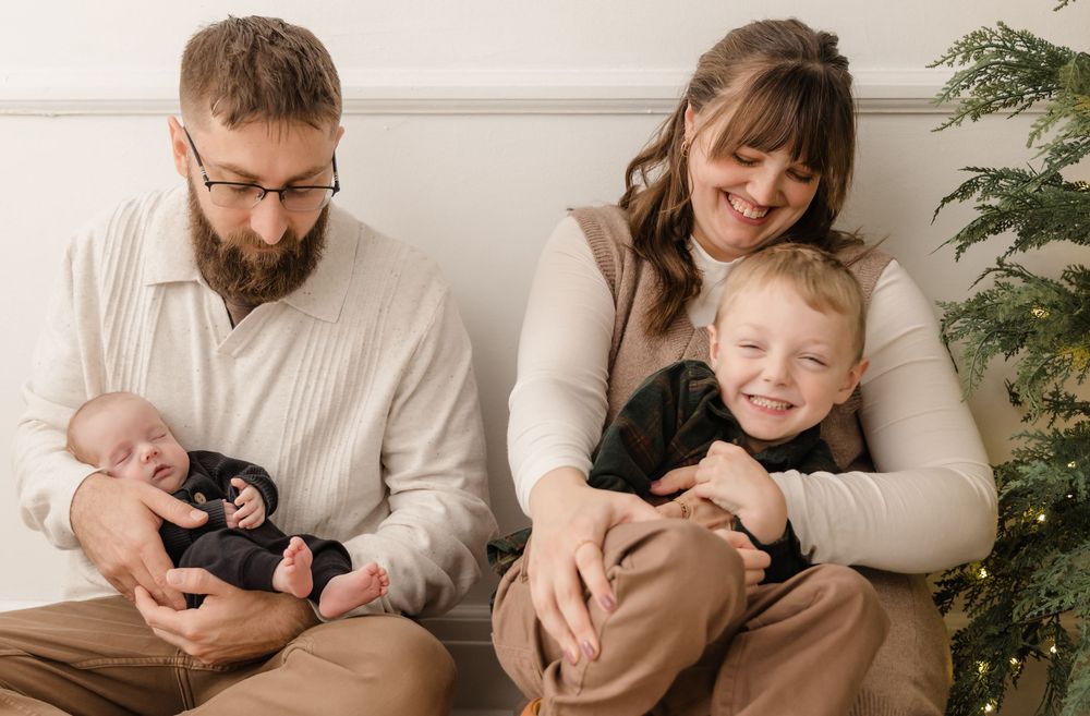 Family relaxing together on couch during intimate lifestyle photo session.