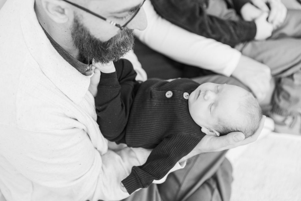 Candid black and white family moment captured during indoor photography session.