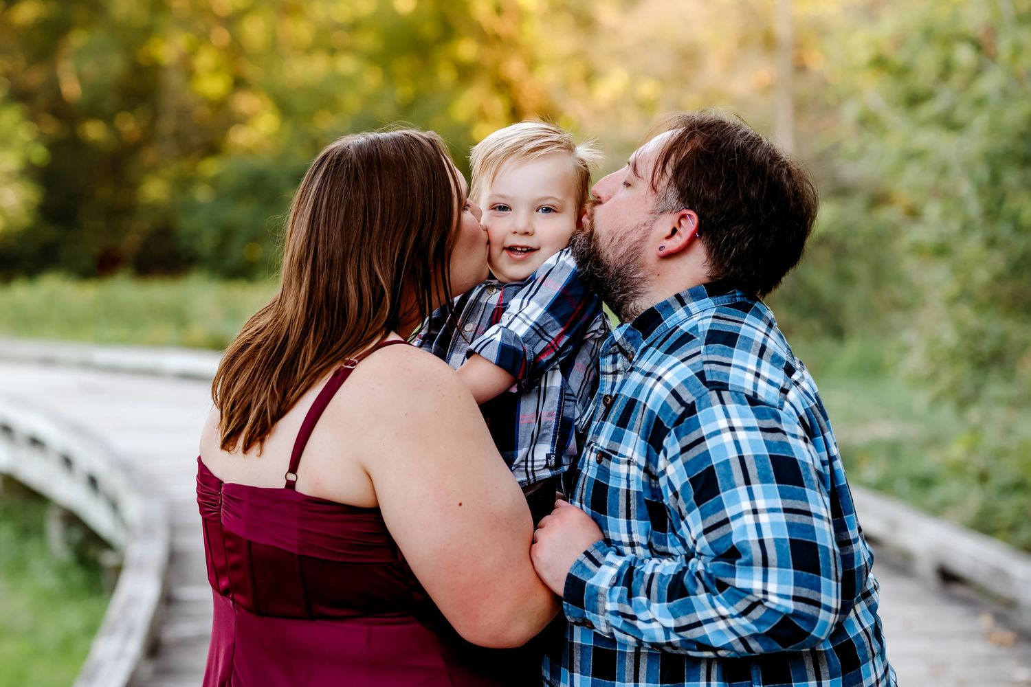 A loving family enjoys playful moments together during an outdoor photo session in a natural setting.