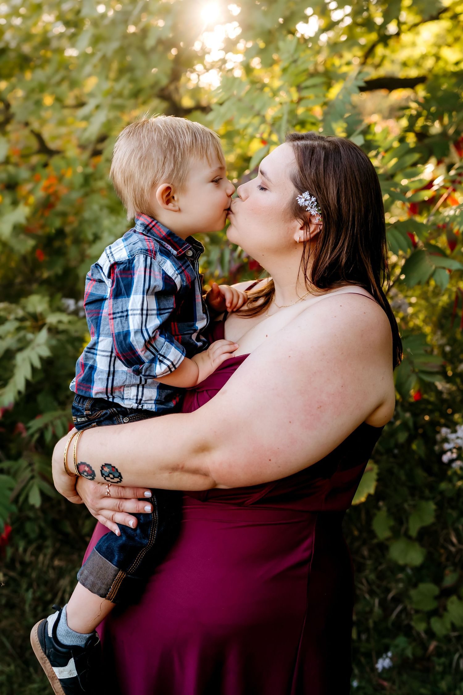 A tender moment between parent and child is captured in a series of outdoor photos with golden sunlight filtering through trees.