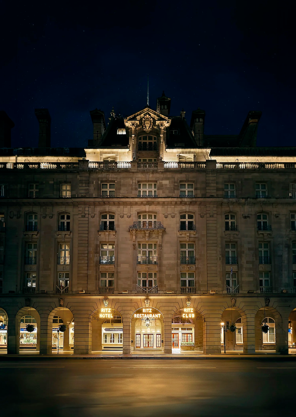 Historic stone building facade lit up at night with classical architectural details.