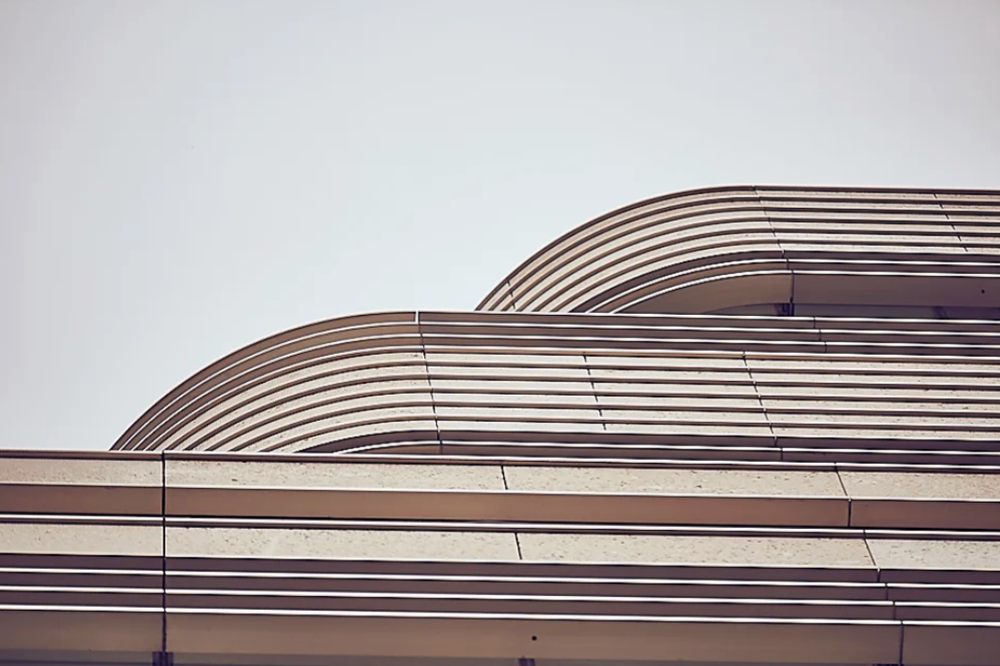 Curved architectural lines forming a geometric pattern against light background.