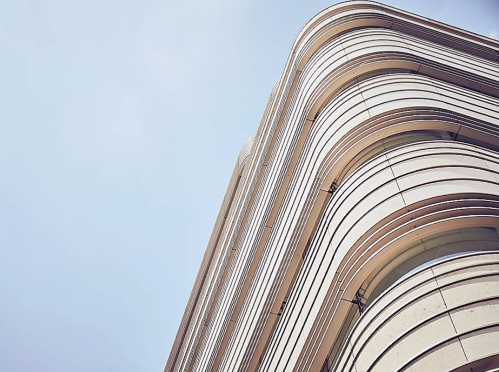 Modern building facade with curved white lines creating a dynamic pattern.