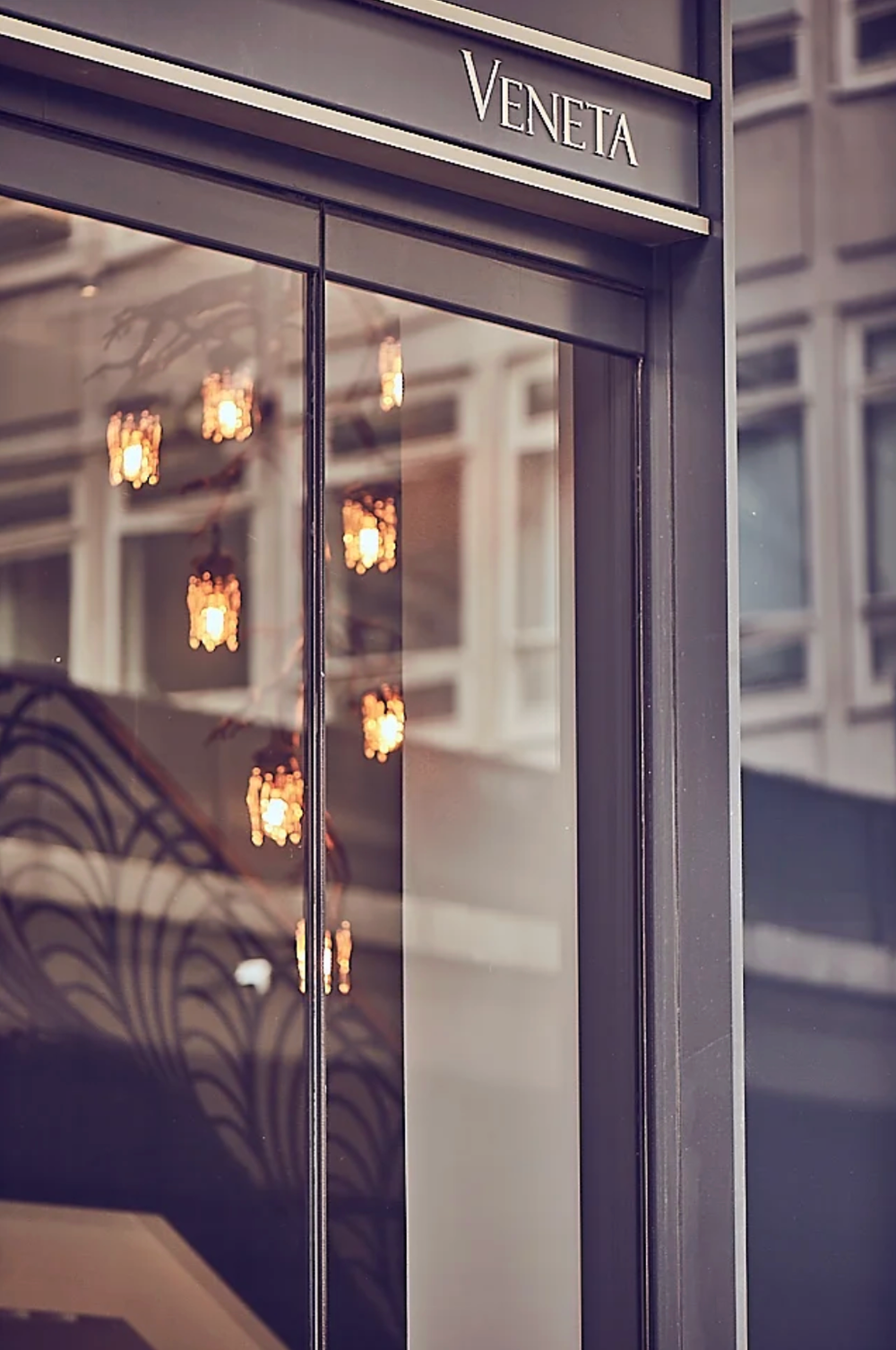 Luxury retail storefront with elegant lighting fixtures and reflective glass.