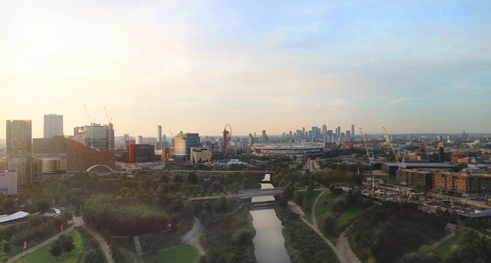 Panoramic cityscape view of London's skyline at sunset with modern buildings and urban architecture.
