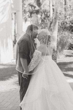 Black and white romantic portrait at an elegant outdoor wedding venue.