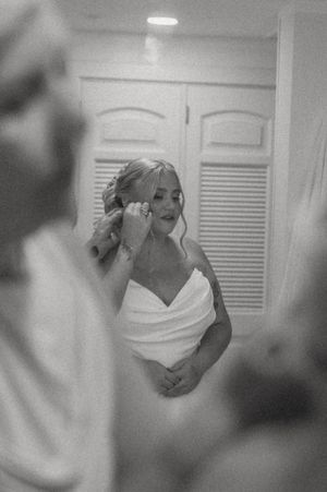 Black and white artistic wedding preparation photo in interior setting.