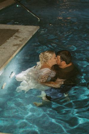 Romantic nighttime pool scene with illuminated turquoise water.