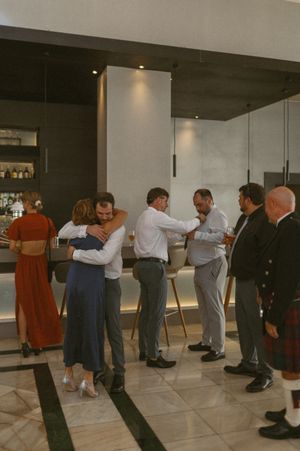Wedding reception guests dancing in pairs in modern indoor venue.