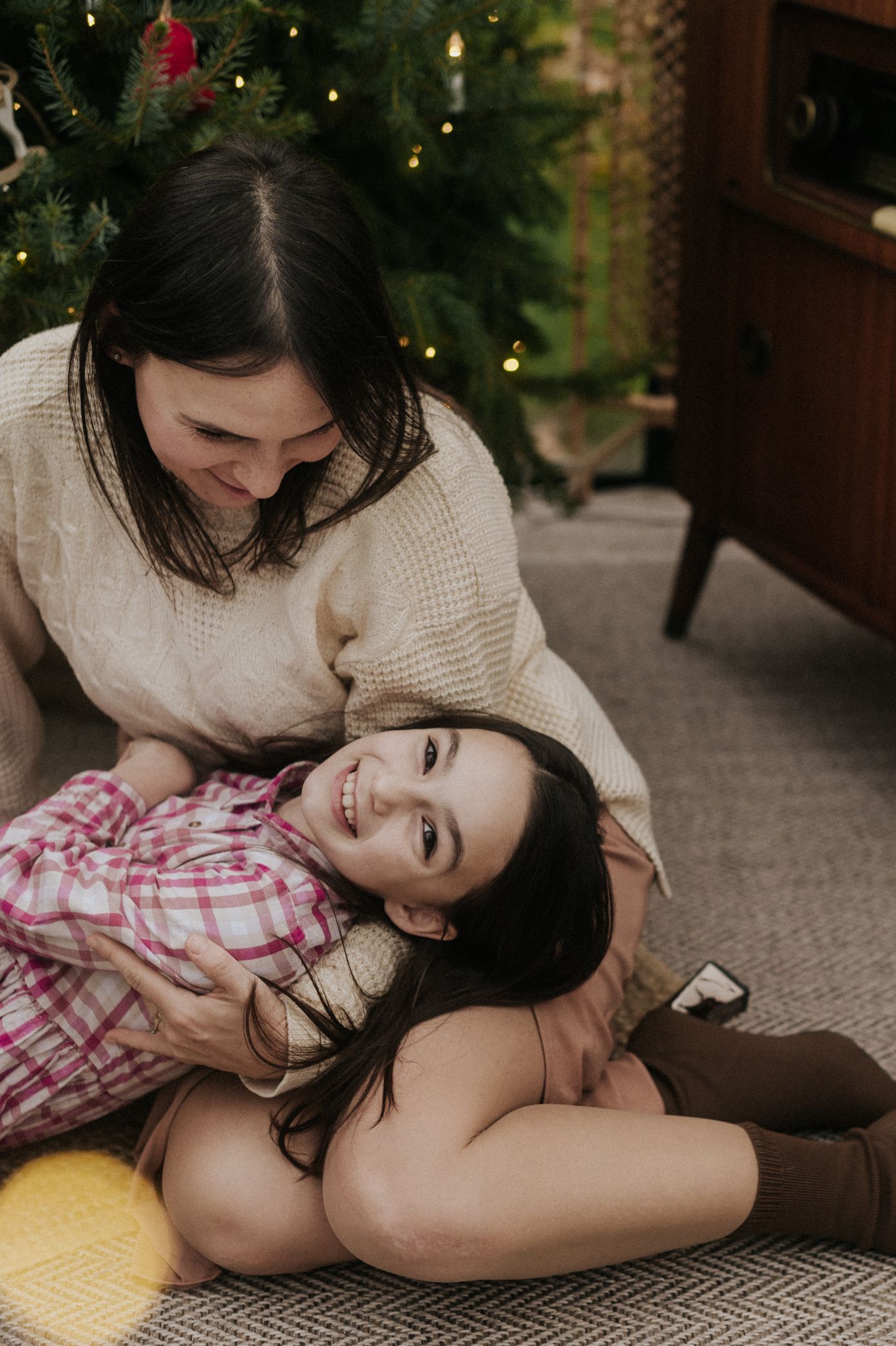 A couple shares an intimate moment while relaxing together on a cozy carpet during the holiday season.