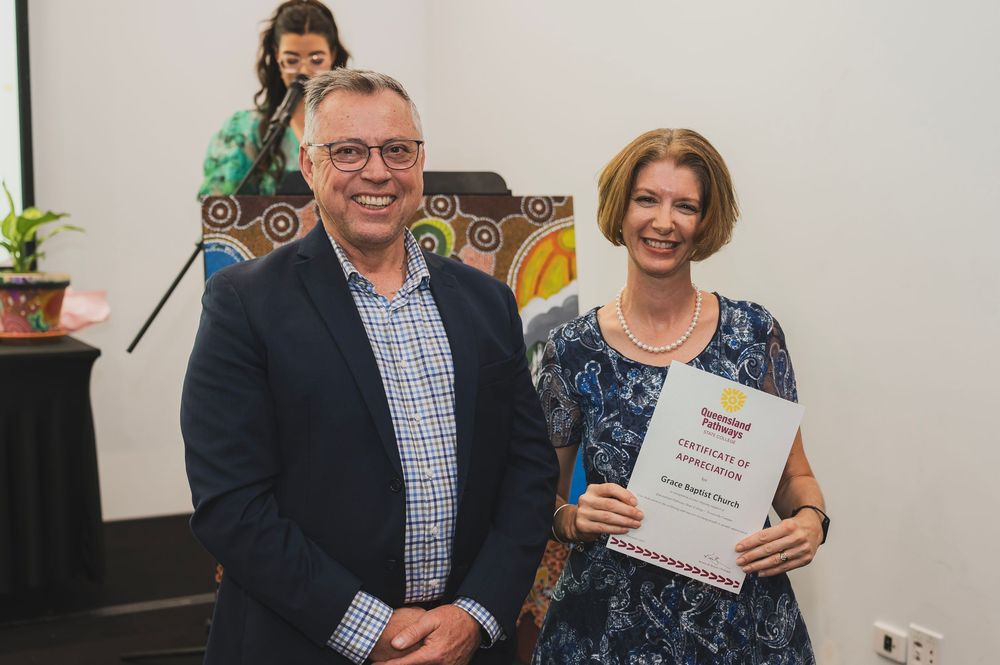 People holding award certificates and smiling during a recognition ceremony.