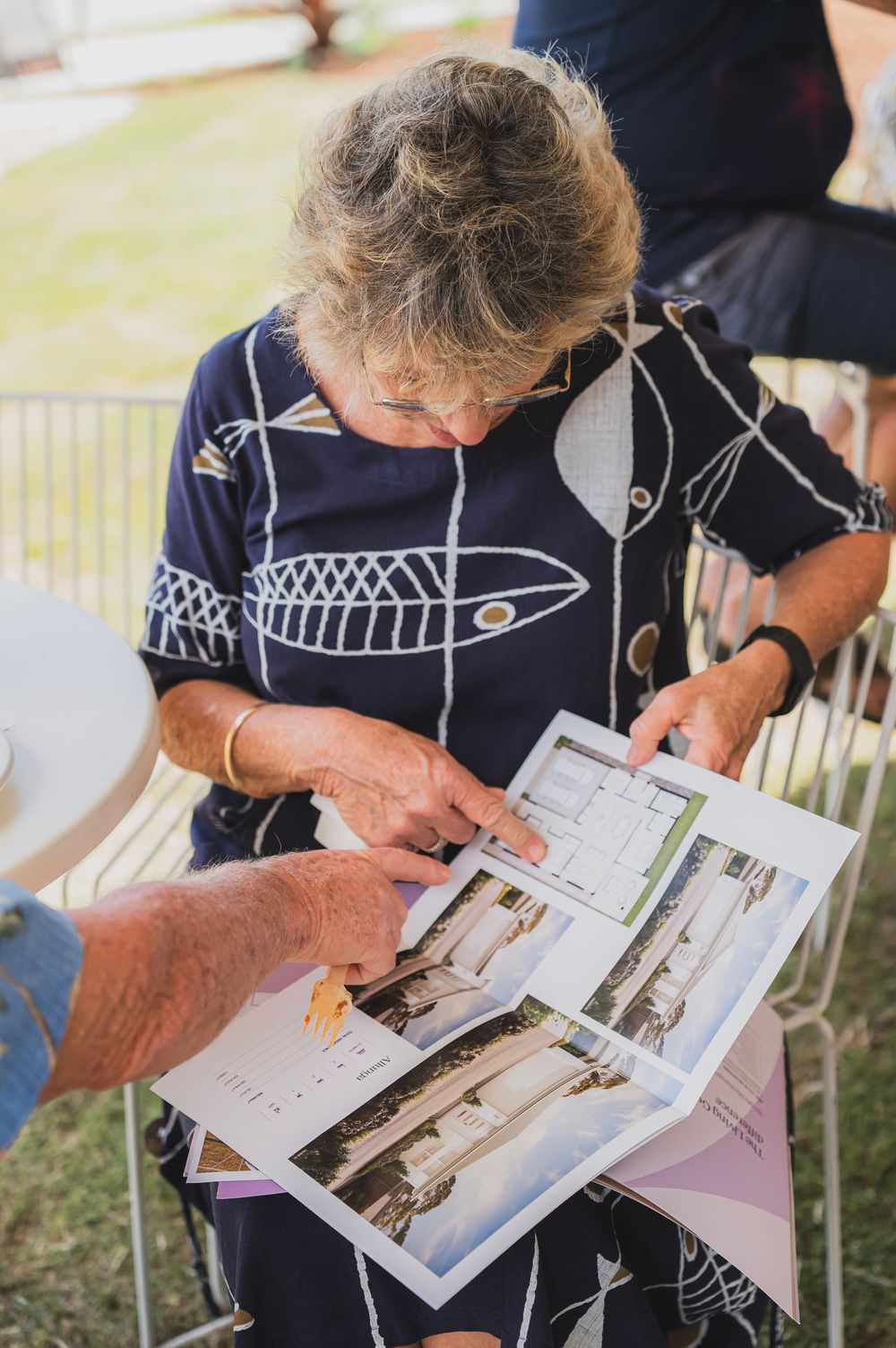Close-up sequence showing hands flipping through pages of a photo book or magazine displaying black and white photographs.
