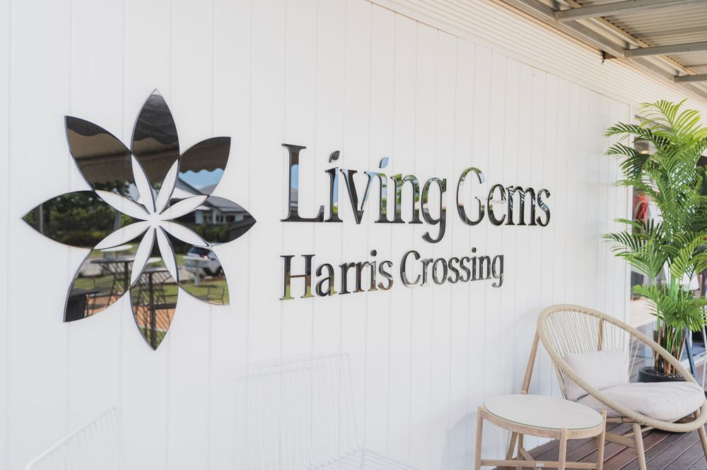 Modern white building facade with Living Gems and Harris Crossing signage displayed.