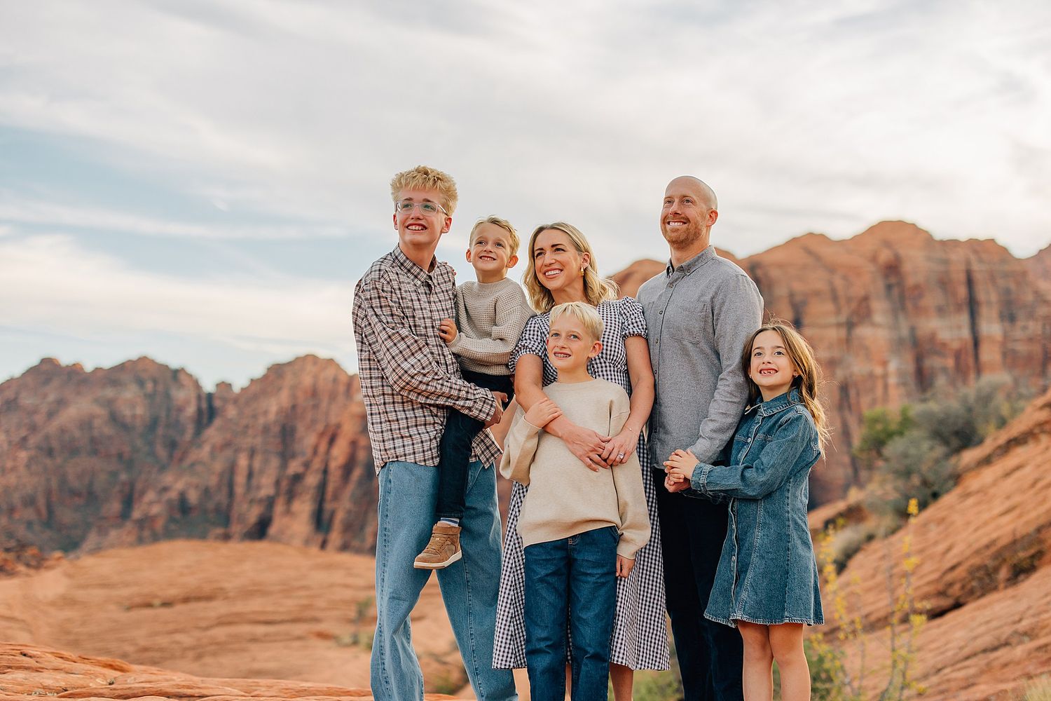 Family portrait with desert canyon backdrop during golden hour photography session.