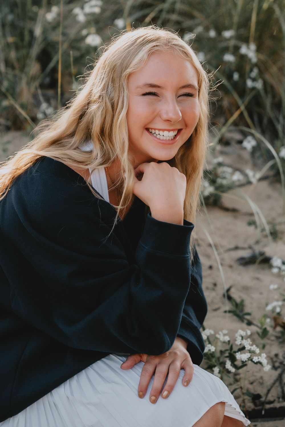 Natural light portrait showing joyful expression while wearing a cozy navy sweater outdoors.