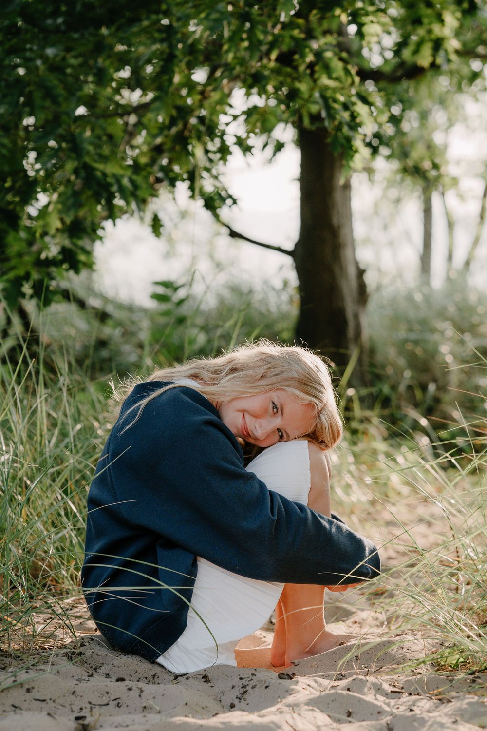 A series of artistic shots showing someone curled up in casual clothing against a natural outdoor backdrop.