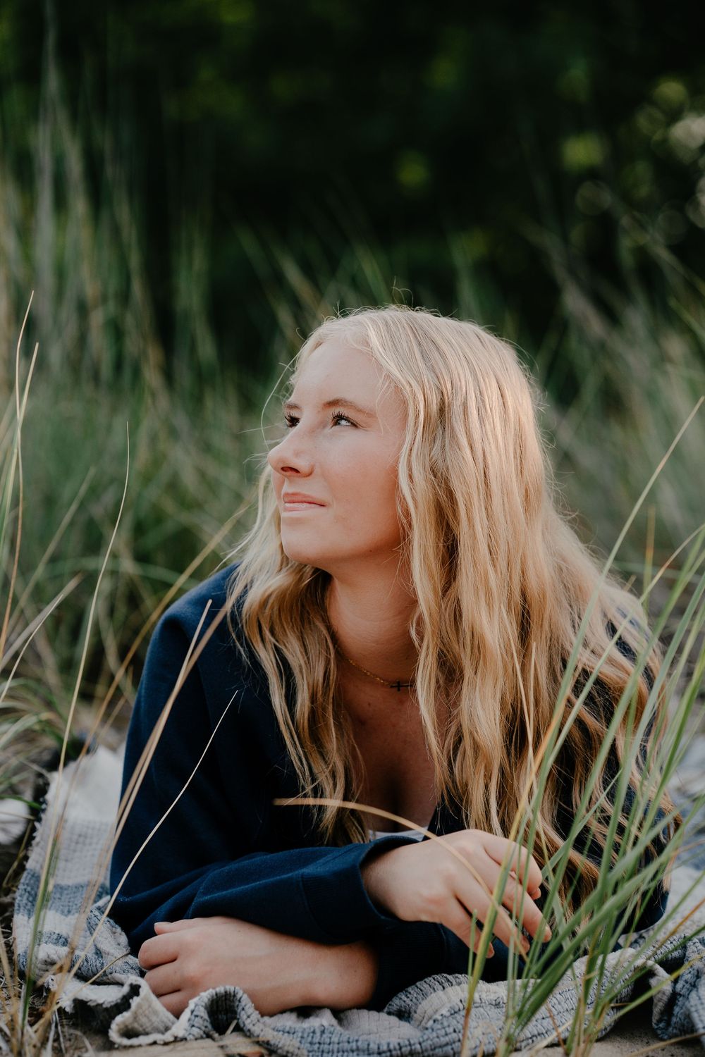 Artistic outdoor photos capture someone resting among wildflowers and grass during a summer evening.