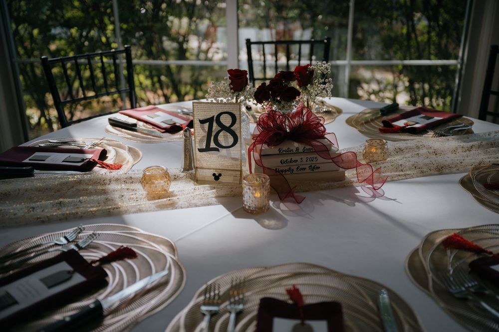 Elegant wedding reception table settings with white linens and pink floral centerpieces in an outdoor venue.
