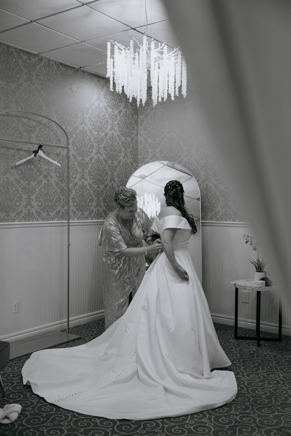 A sequence of black and white photos showing a bride in a flowing white wedding gown posing elegantly in a formal room.