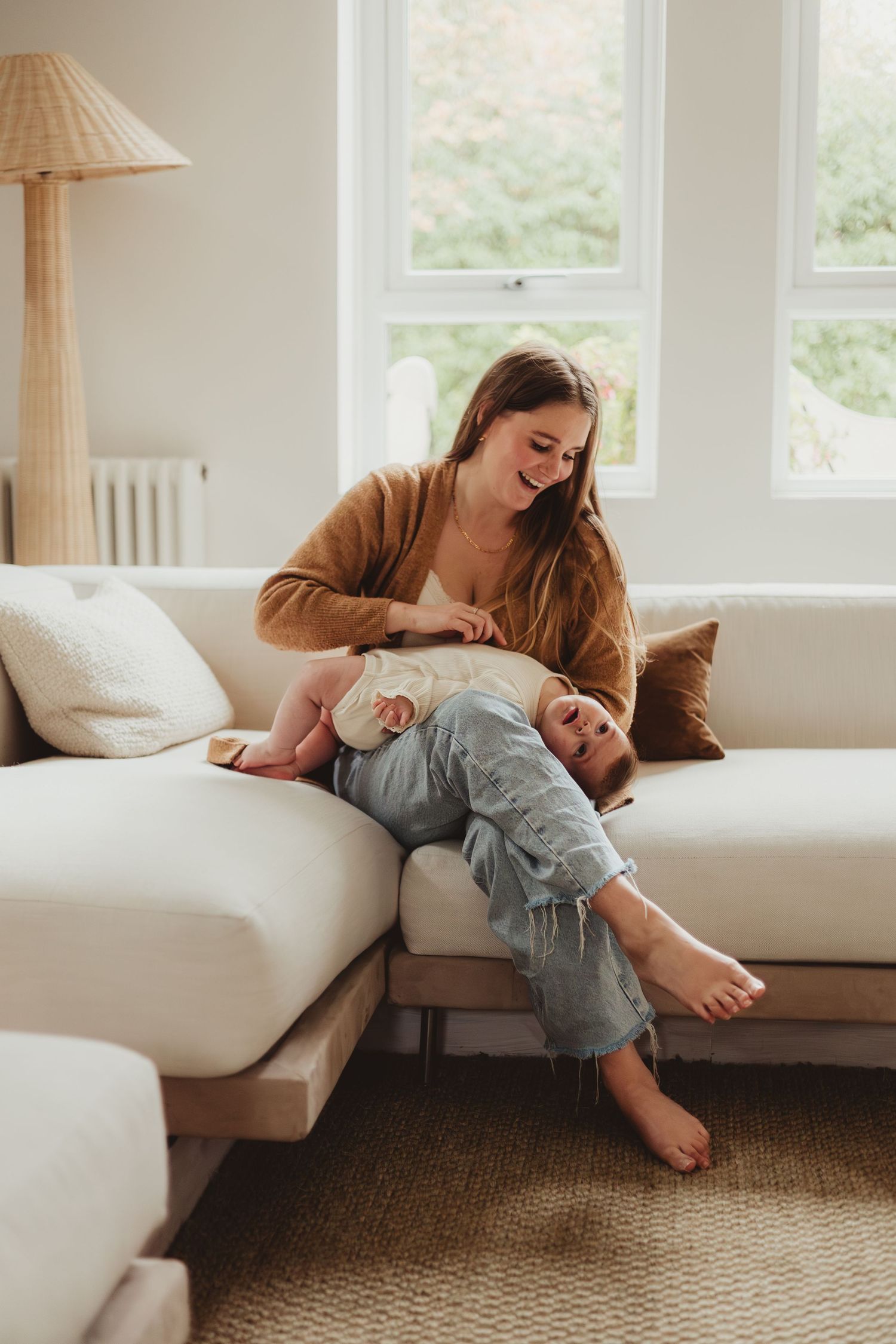 Playful family moment on couch with laughter and upside-down fun.