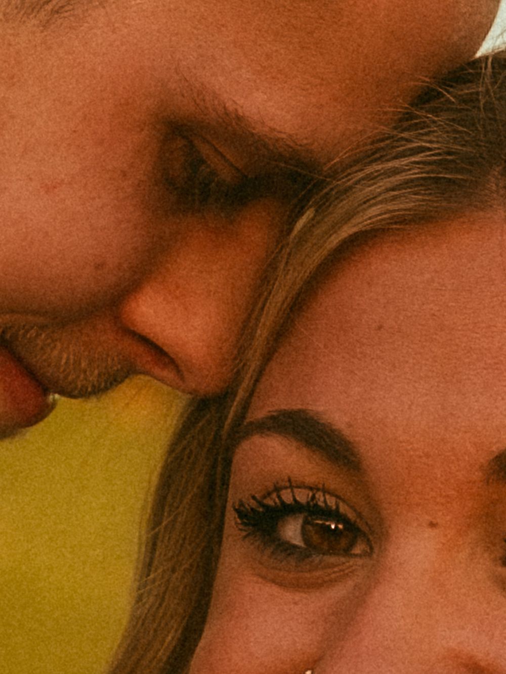 Romantic close-up of couple sharing tender kiss with warm golden light.