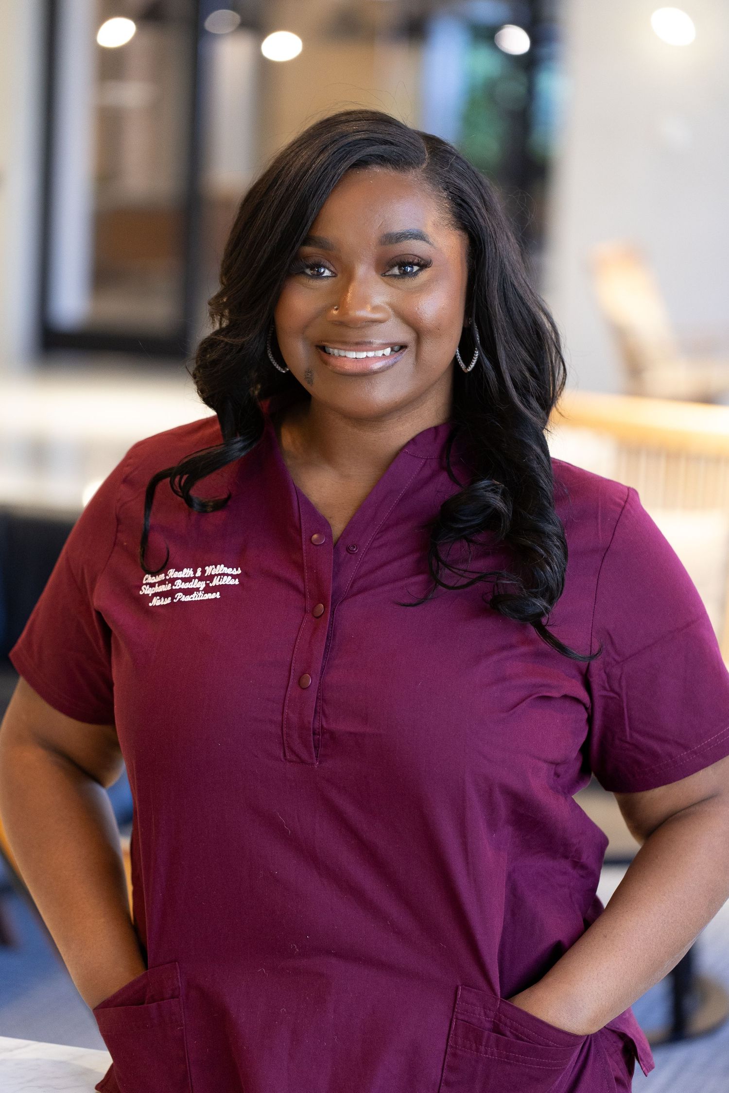 Professional in burgundy medical scrubs smiles warmly in a series of four connected headshots.