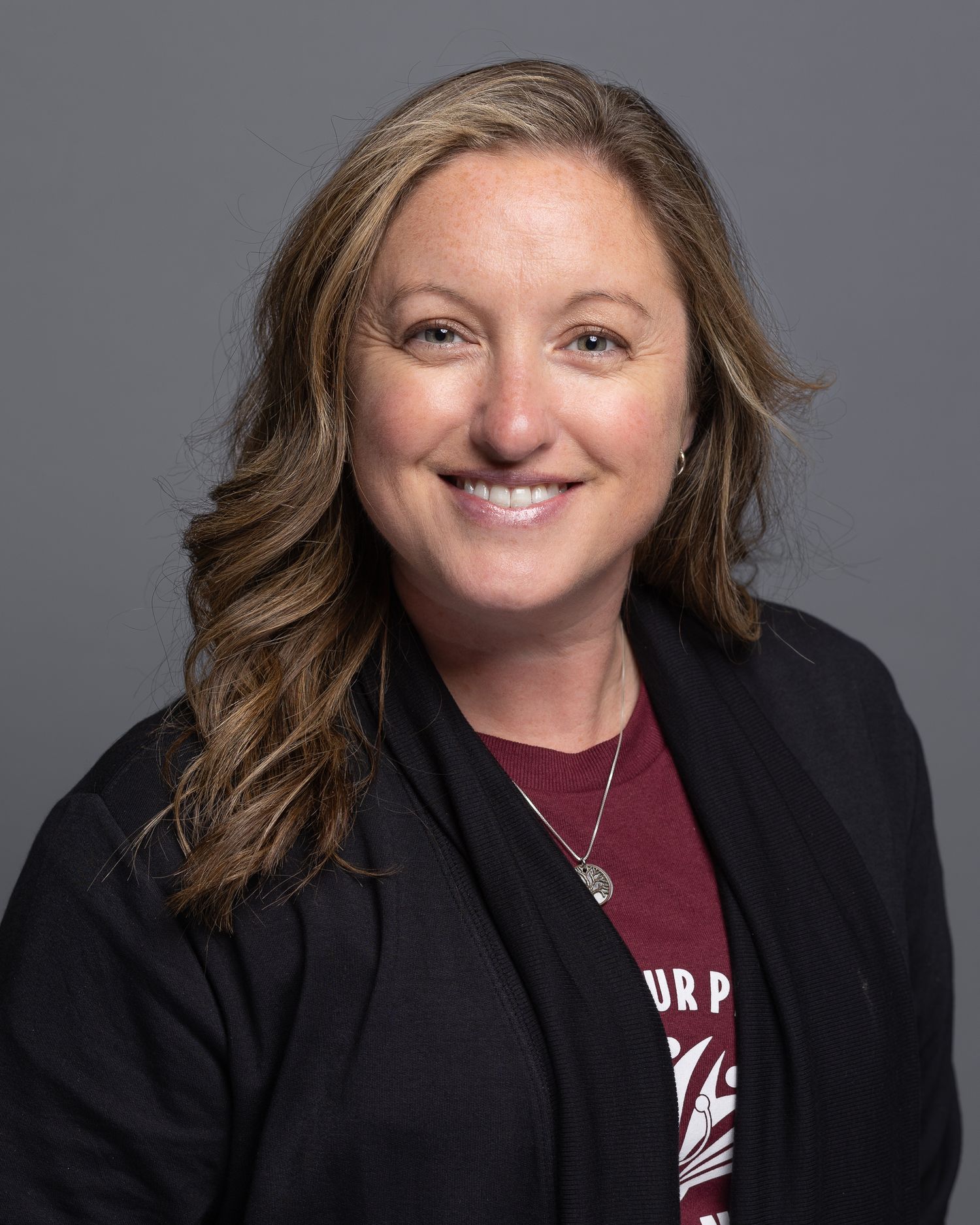Series of professional portraits showing person in burgundy shirt and black blazer with warm smile.
