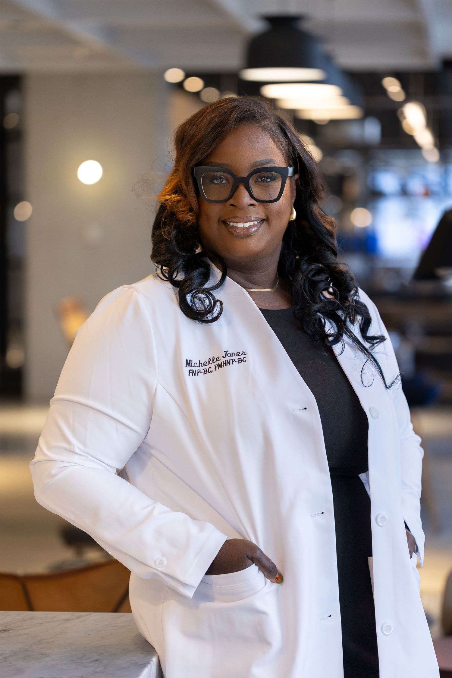 Professional wearing a white lab coat and glasses poses confidently in a modern office setting.