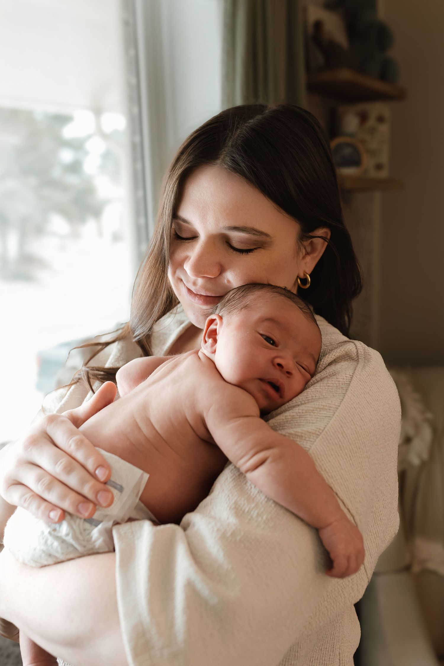 A tender moment between parent and newborn baby in soft natural window light. Colorado Springs Photographer.