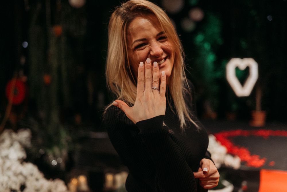 Emotional reaction captured in low light with hands covering face.