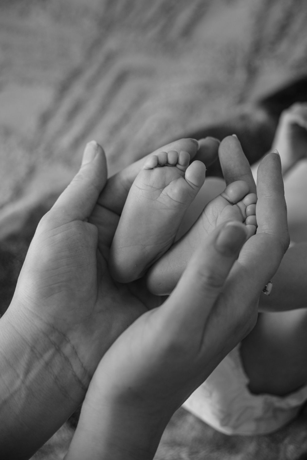 Newborns feet being cradled by mothers hands