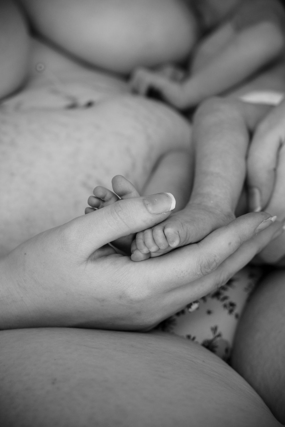 Mother holding newborns foot