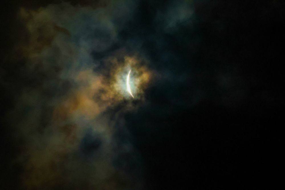 Ethereal celestial scene showing bright light breaking through dark storm clouds.