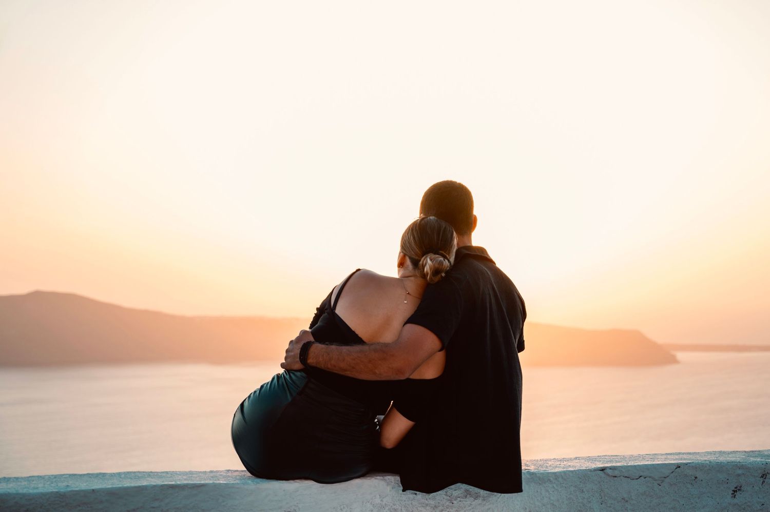 A silhouette of a couple embracing while watching sunset over the Mediterranean Sea.