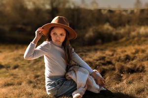 Children in casual outfits play together outdoors on a sunny autumn day in a natural setting.