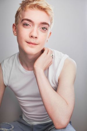 Headshot of actor Zell Morrow win a white tank top sitting with his head resting on his hand.
