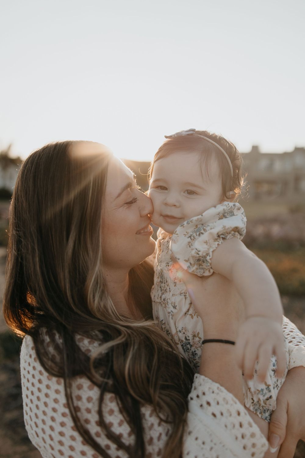 Row of intimate family portraits captured against soft sunlit background in warm tones.