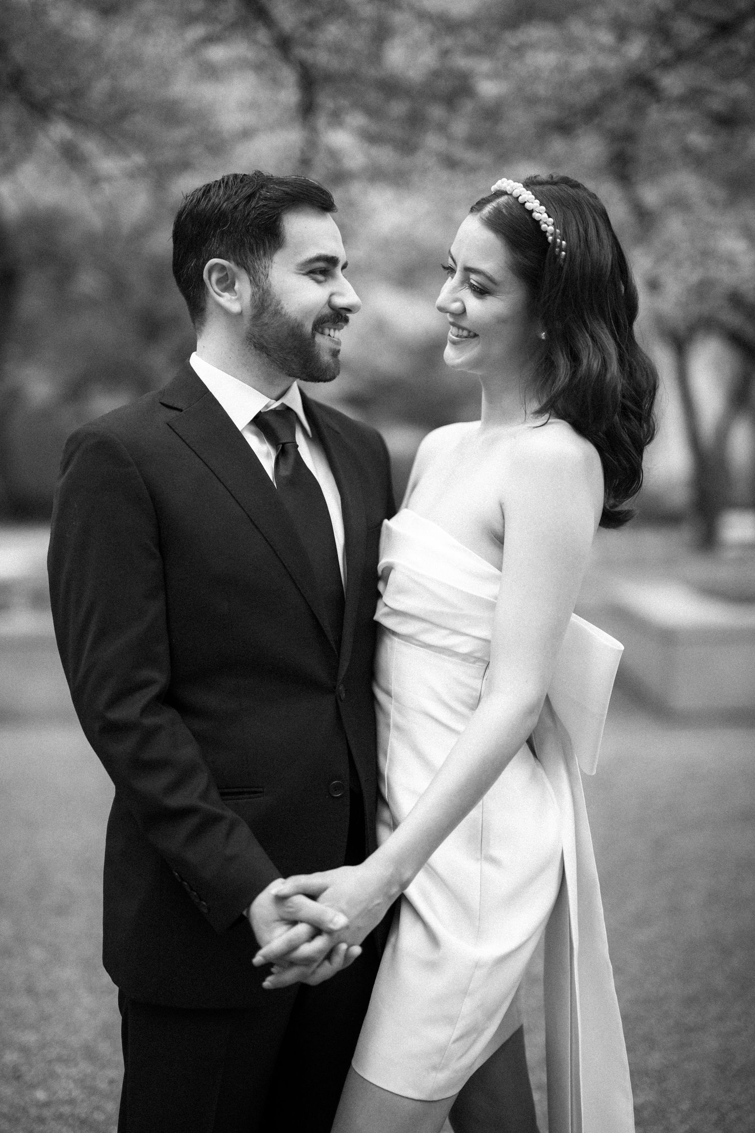Intimate black and white portrait of a couple in wedding attire sharing a loving moment.