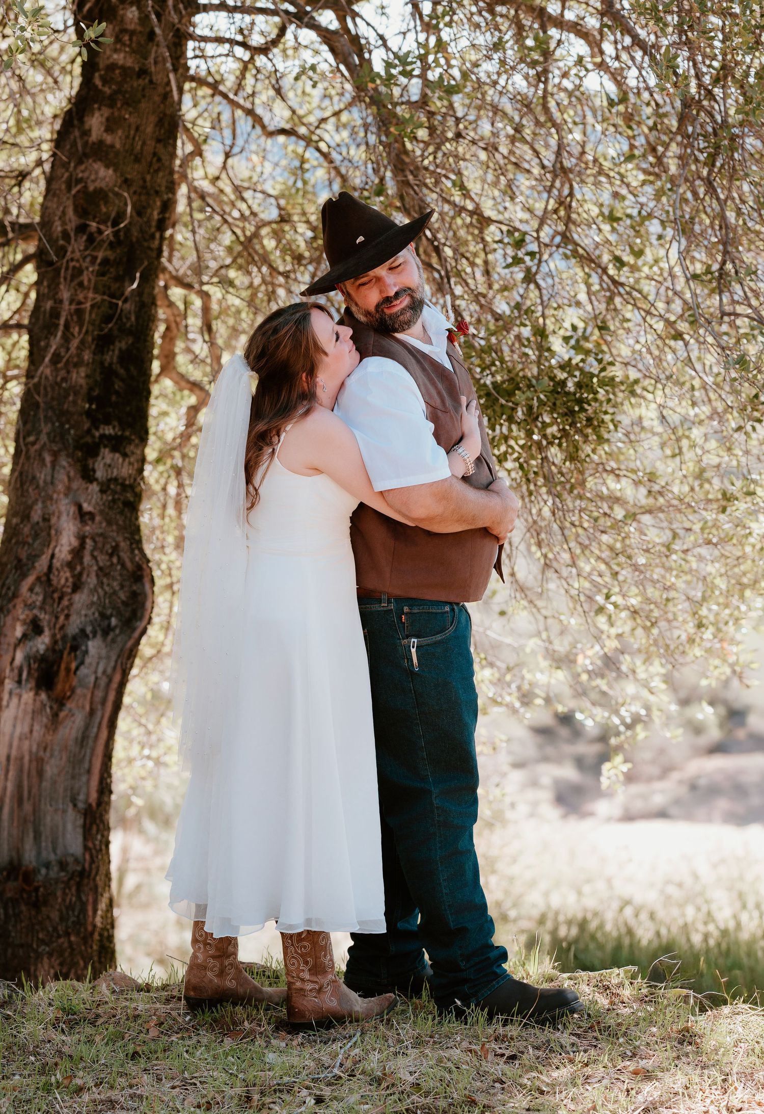 A romantic couple shares tender moments under blossoming trees in a dreamy outdoor setting.