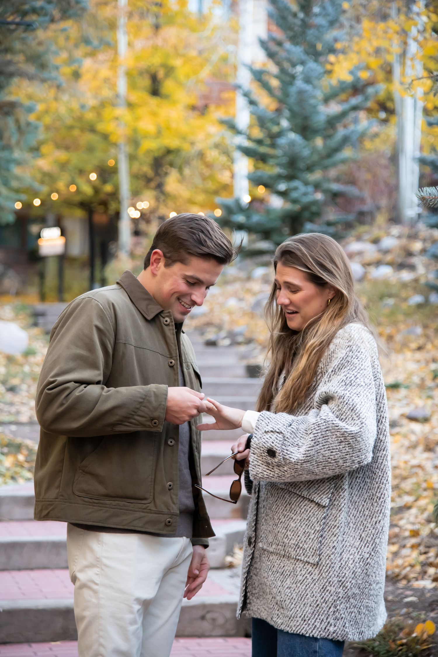 A cute couple admiring her new engagement ring after a surprise proposal in Vail Village during the fall