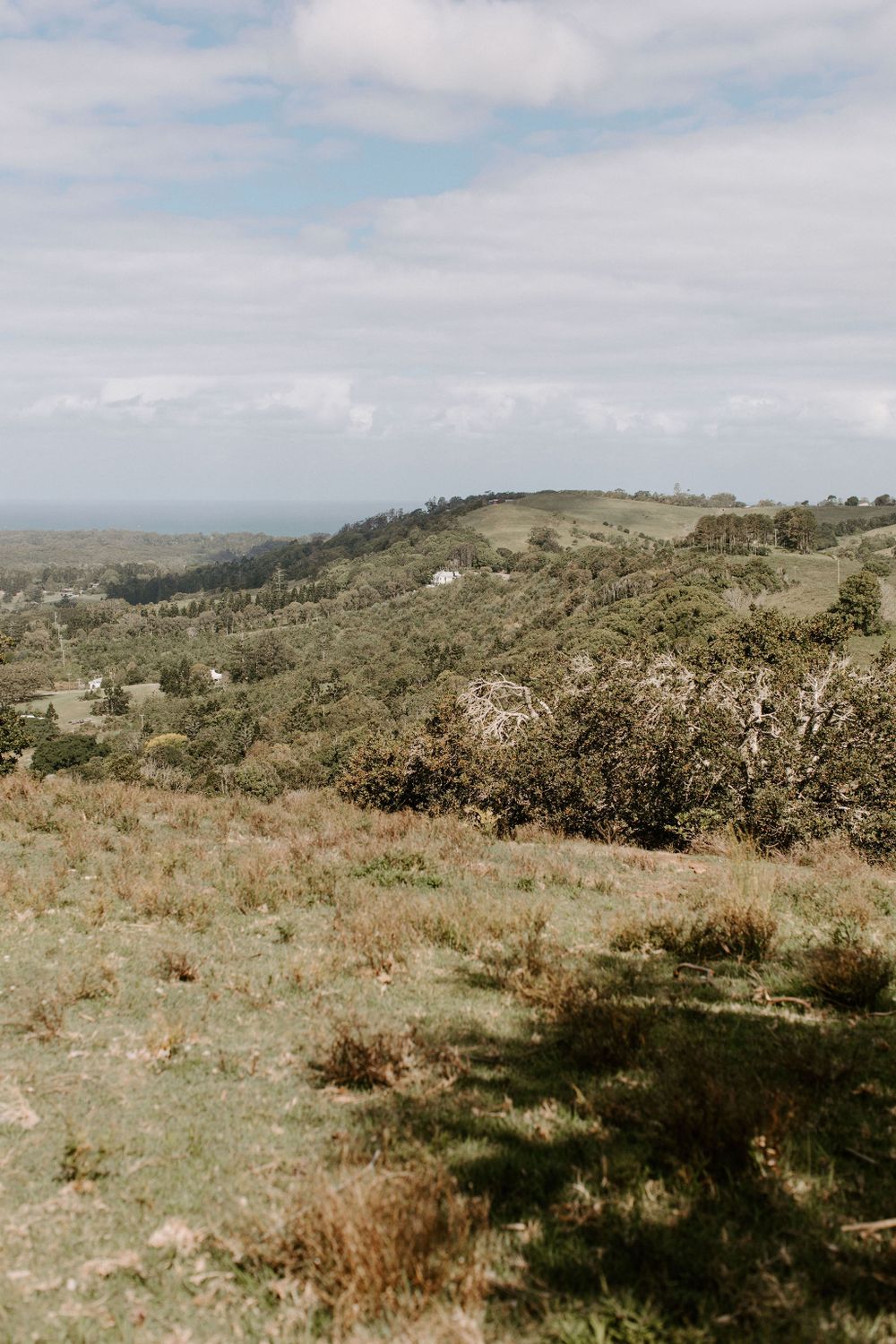 Scenic view of green hills and valleys stretching towards distant mountains.