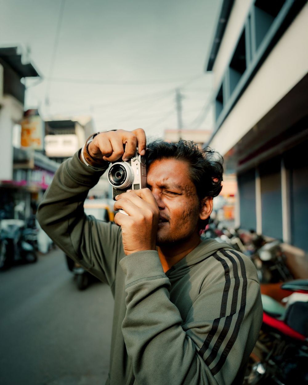Someone taking photographs with a camera from different angles on a city street.