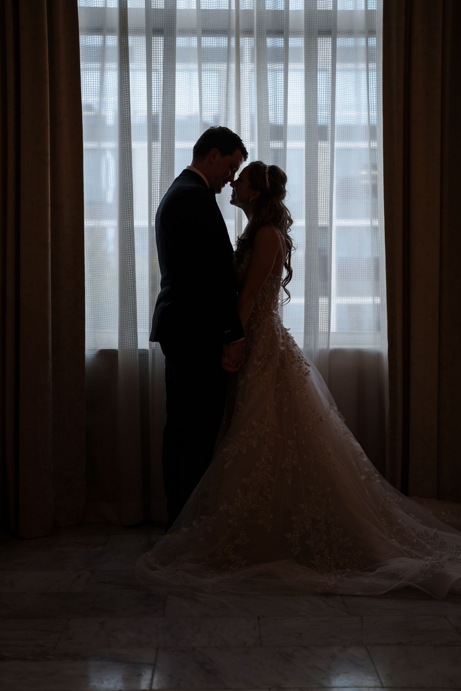 Silhouetted couples pose against window light create romantic wedding day ambiance at The Westin Great Southern Columbus